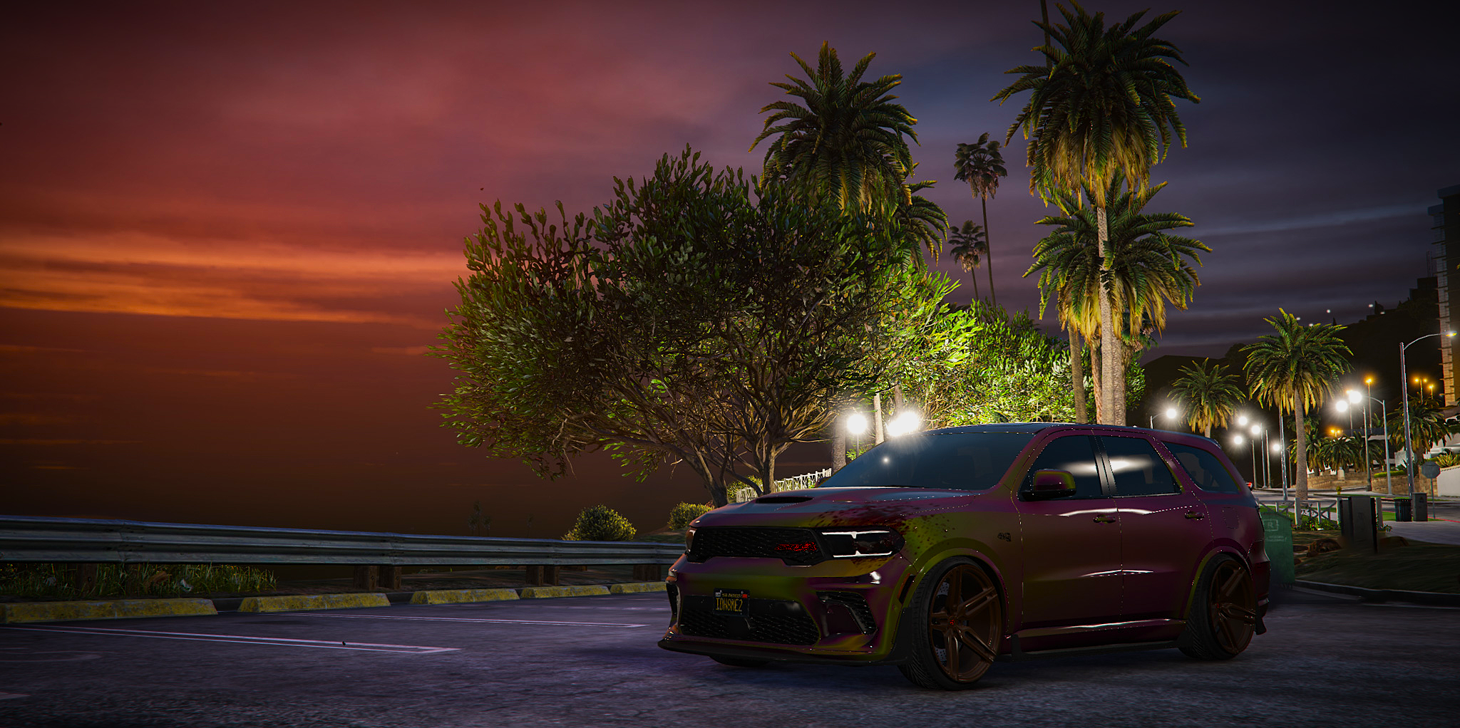 Widebody Dodge Durango SRT with an iridescent purple and gold wrap parked at a palm-lined coastal overlook at sunset