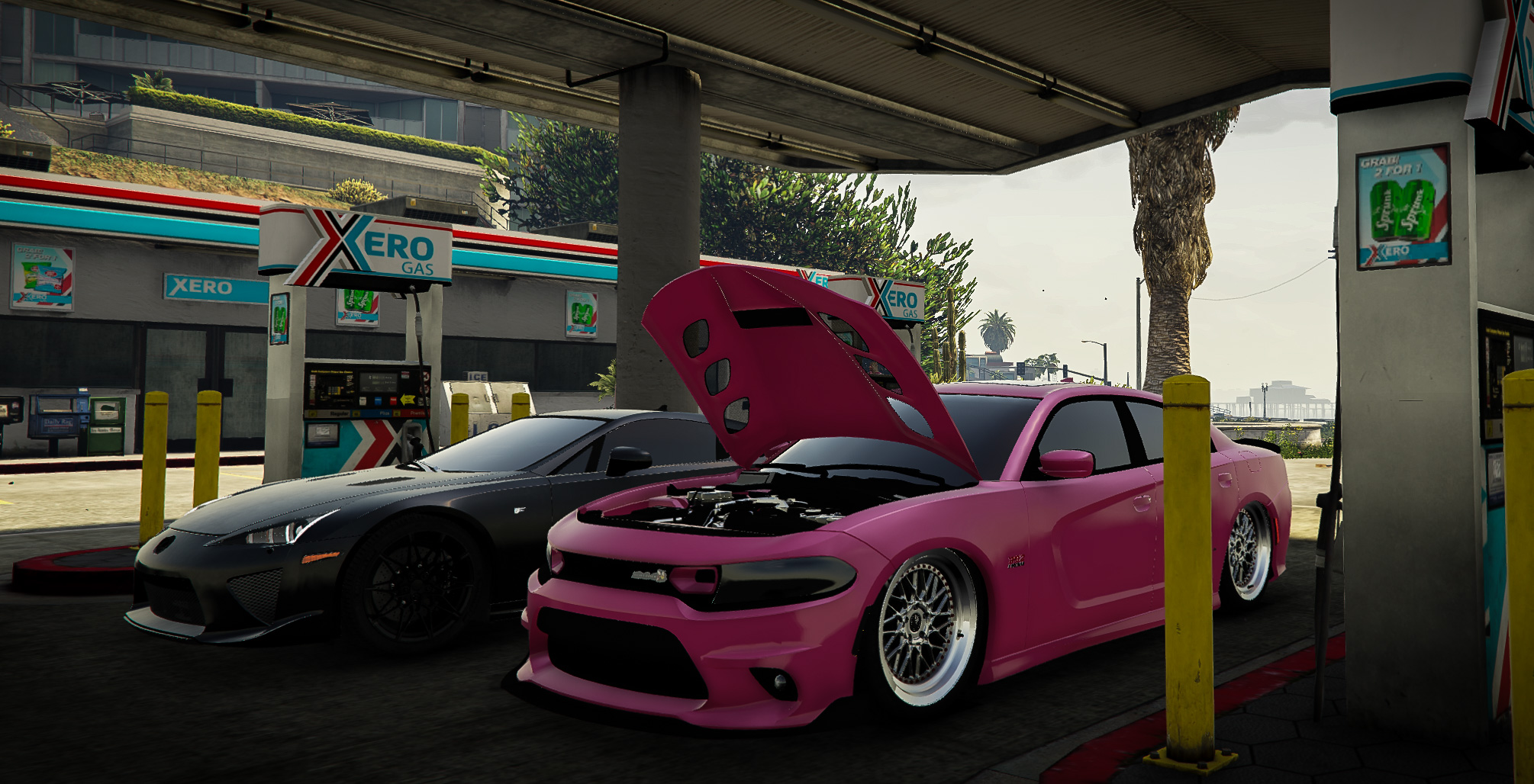 Pink widebody Dodge Charger with its hood up beside a black Lexus LFA at a gas station